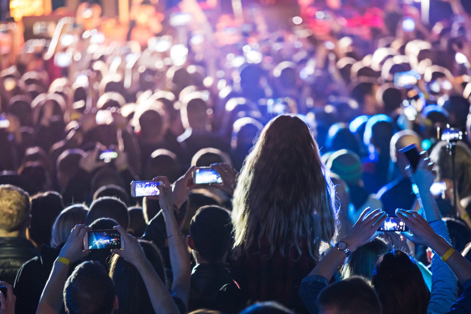 The silhouettes of concert crowd in front of bright stage lights. Concert of an abstract rock band